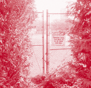 red and white image. a chained gate is centered between 2 bushes. on the right side there is a notice that reads "NOTICE. PERSONS USING THIS WALK DO SO AT THEIR OWN RISK"