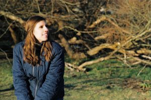 portrait of dee stacey sitting in front of trees looking to the side