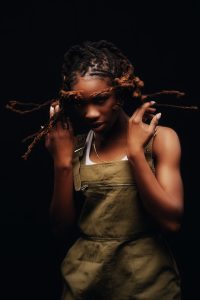 portrait photo of Haviah Mighty with her hair in motion around her in front of a black backdrop by Yung Yemi